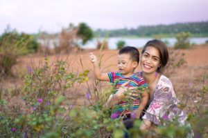 woman hugging boy on field