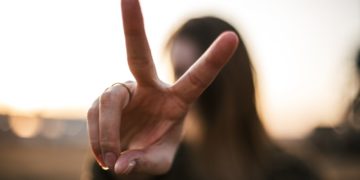 focus photography of woman hand with peace sign
