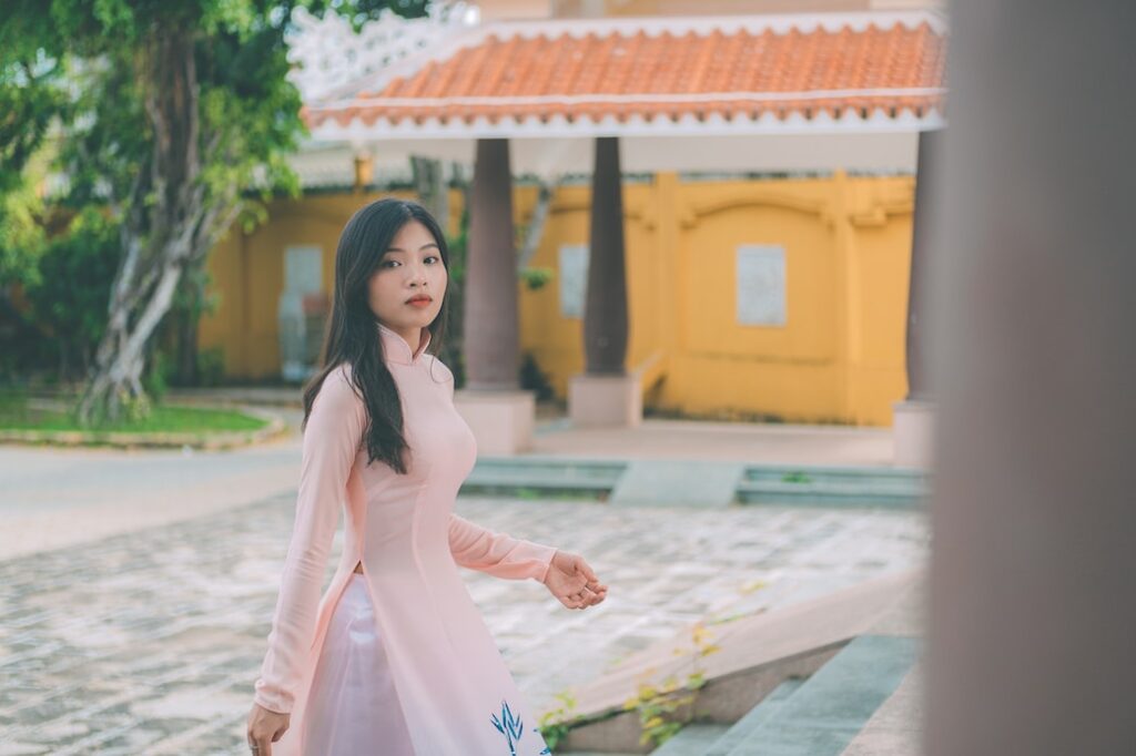 a woman in a pink dress walking down a street