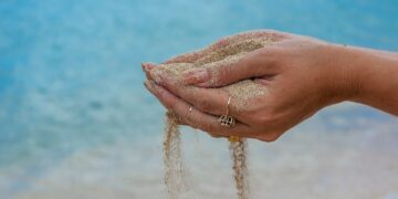 person wearing silver ring on water