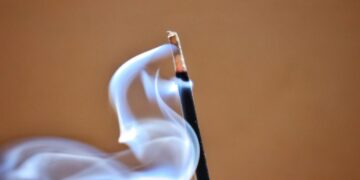 A close up of a matchstick with smoke coming out of it