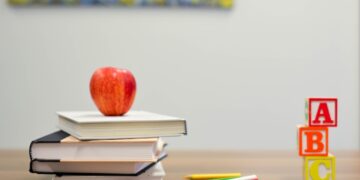 red apple fruit on four pyle books
