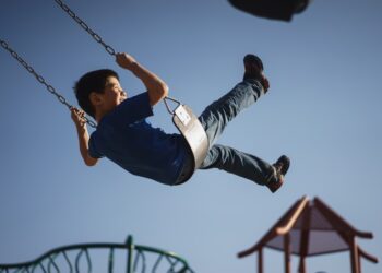 boy sitting on swing chair