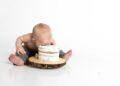 kid sitting beside round cake close-up photography
